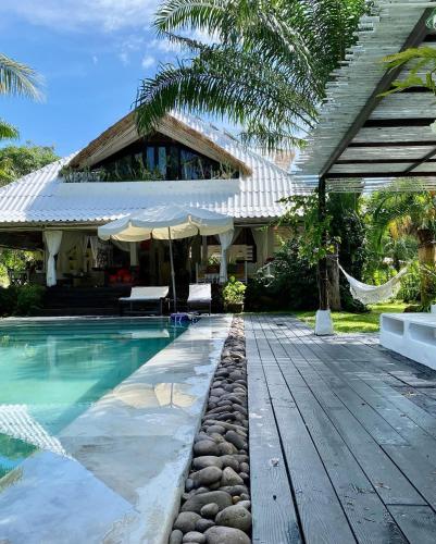a house with a swimming pool with a hammock and a house at Maddekehaoo Eco Mansion in Ko Chang