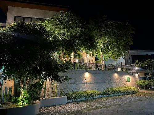 un bâtiment avec des lumières sur un mur la nuit dans l'établissement 233Poshtel, à Lampang