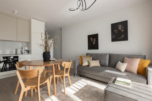 a living room with a table and a couch at Scala Apartamenty by Moderna Profit- Łąkowa 60E z parkingiem in Gdańsk