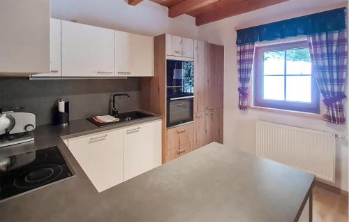 a kitchen with white cabinets and a window at Ferienhuette In Lachtal in Hinteralm