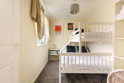 a childs bedroom with a white bunk bed at Fabulous Beach Pad Just 20 Paces From The Sea in Mawgan Porth