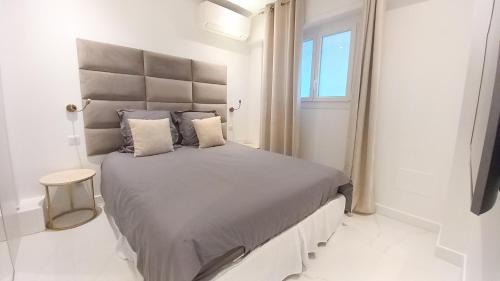 une chambre avec un grand lit avec une grande tête de lit dans l'établissement Le Palais Des Iles, à Cannes