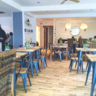 a dining room with blue tables and chairs in a restaurant at Fabulous Beach Pad Just 20 Paces From The Sea in Mawgan Porth