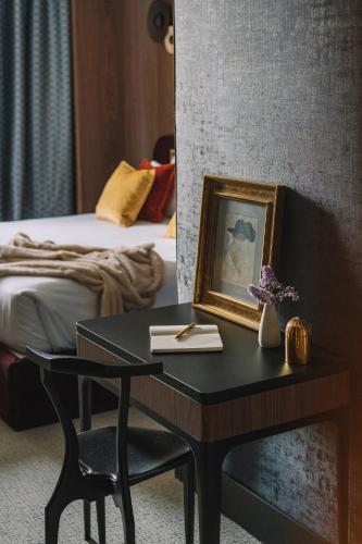 a table with a picture on it next to a bed at Hotel Pinar Plaza in Madrid