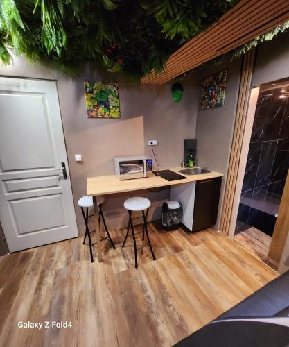 - une cuisine avec un bureau, un four micro-ondes et des tabourets dans l'établissement Appt Avengers à 10 minutes de Disneyland, à Condé-Sainte-Libiaire