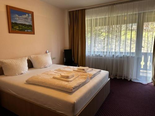 a hotel room with a large bed with a window at Schwanen-Resort in Baiersbronn
