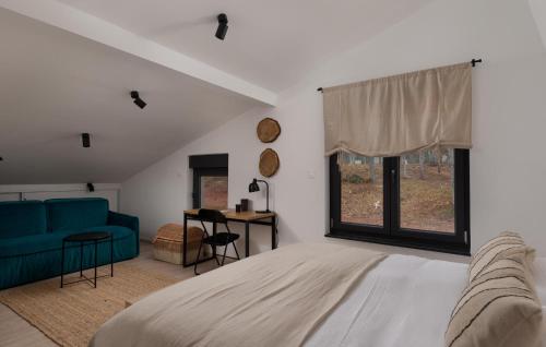 a bedroom with a bed and a blue couch at Amazing Home In Rizvanusa in Gospić