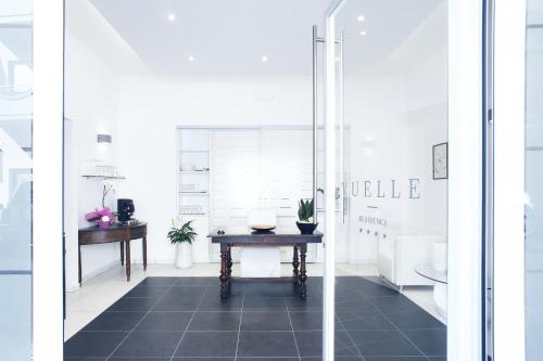 Habitación blanca con mesa y lavamanos en Vuelle Residence Apartments, en Capo dʼOrlando