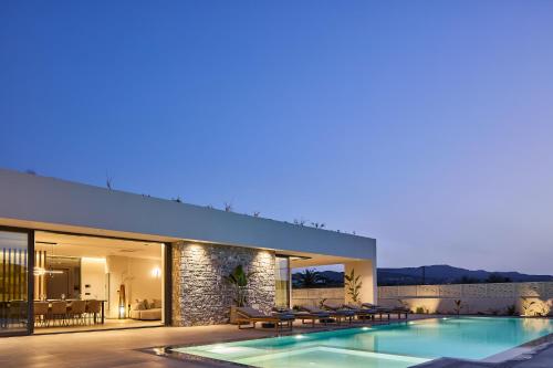 a villa with a swimming pool at night at Manza Villa in Sfakaki