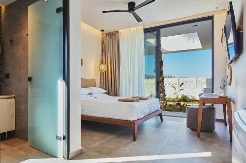 a bedroom with a bed and a large window at Manza Villa in Sfakaki