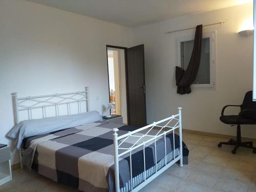 une chambre avec un lit, un bureau et une chaise dans l'établissement Villa T4 à Campomoro corse du sud, 800m plage, à Belvédère