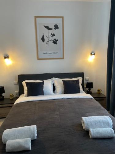 een slaapkamer met een groot bed en 2 handdoeken bij Cozy Apartment Sfanta Vineri Zalau in Zalău