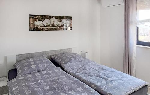 uma cama num quarto com uma fotografia na parede em Beautiful Home In Musales With Outdoor Swimming Pool em Mušalež