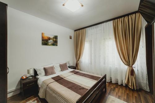 A bed or beds in a room at Casa de Vinuri Vranceana