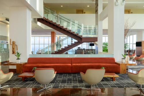 a lobby with a red couch and a staircase at Hotel Luzeiros São Luis in São Luís