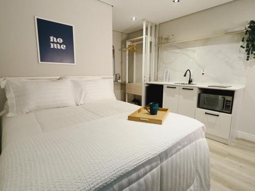 a bedroom with a white bed with a tray on it at Apê Paulista Alameda Santos in São Paulo