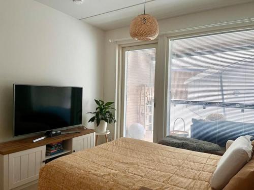 a bedroom with a flat screen tv and a bed at Ingas, Espoo- Whole apartment in Espoo