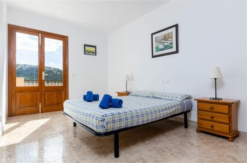 a bedroom with a bed with blue pillows on it at YourHouse Sol i Mar 1 beach apartment in Cala Mesquida