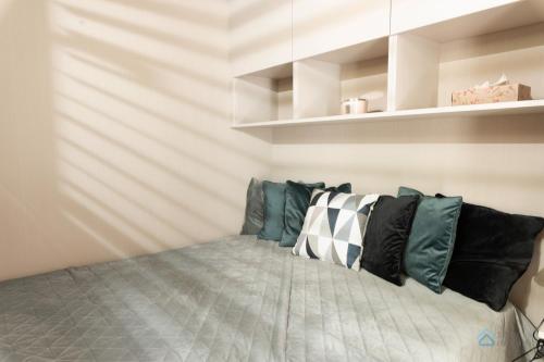 Un dormitorio con una cama con almohadas. en Garden Studio by 3City Rentals en Gdynia