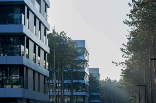 ein hohes Gebäude mit Bäumen davor in der Unterkunft Baltic Seasons by Alluxe Boutique Apartments in Rogowo