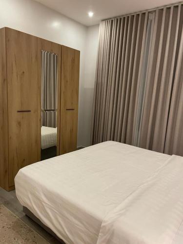 1 dormitorio con 1 cama blanca grande y espejo en Rose 3 en Al Khobar