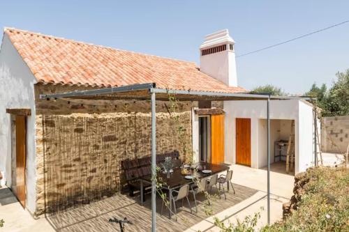 a patio with a table and a building at Casa da Figueira - Pool and Lounge in Praia do Ribatejo
