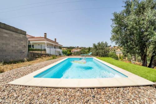 a swimming pool in the middle of a yard at Casa da Figueira - Pool and Lounge in Praia do Ribatejo