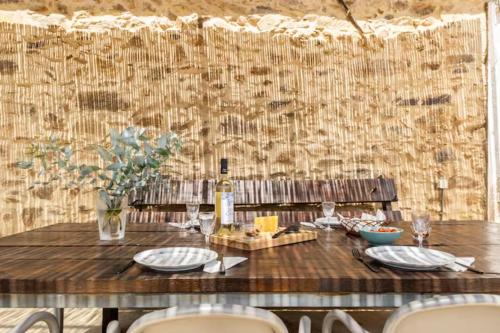 a wooden table with a bottle of wine on it at Casa da Figueira - Pool and Lounge in Praia do Ribatejo