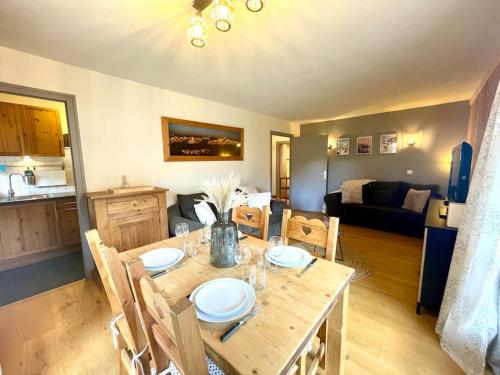 une salle à manger avec une table et un salon dans l'établissement Rez de Jardin, Les Gets, Rénové et Calme, aux Gets