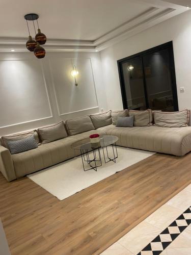 salon z kanapą i stołem w obiekcie Villa avec piscine privée sur agadir w mieście Agadir