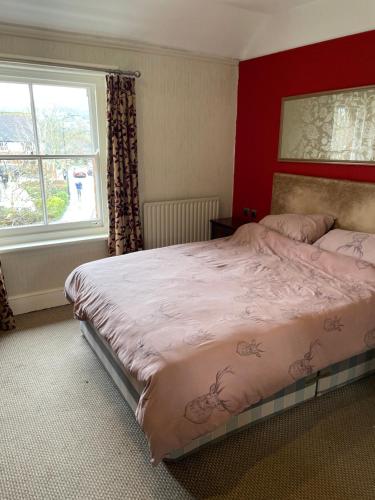 Un dormitorio con una cama grande y una ventana en The bucks head hotel, en Church Stretton