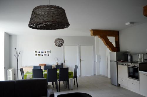 une cuisine et une salle à manger avec une table et des chaises dans l'établissement Les Logis du Hallay, à La Haie-Fouassière