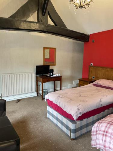 a bedroom with two beds and a desk in a room at The bucks head hotel in Church Stretton