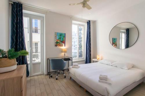 une chambre avec un lit, un bureau et un miroir dans l'établissement #21 2 Bdr balconies 10 mins walk to sea 5mins to tram, à Nice