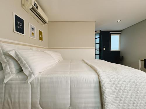 a bedroom with a white bed with white pillows at Apê Paulista Alameda Santos in São Paulo