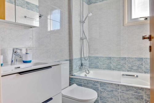 La salle de bains est pourvue d'une douche, de toilettes et d'une baignoire. dans l'établissement Phaedrus Living: Modern City Flat Elpida, à Strovolos