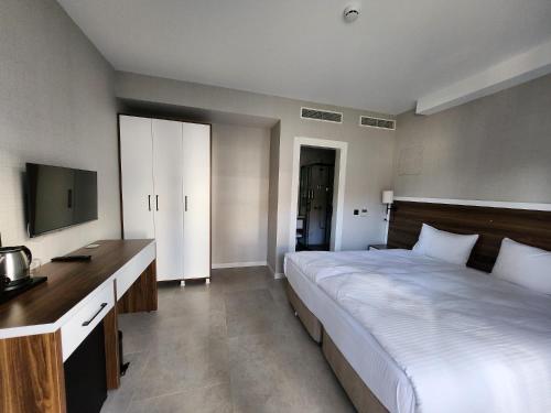 a bedroom with a large bed and a television at Lulubay Rooms & Suites in Kusadası