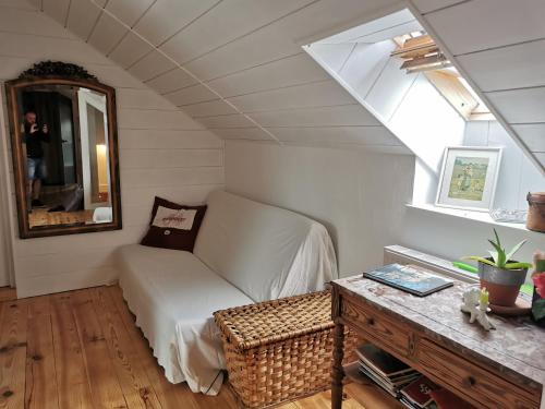 Cette chambre comprend un canapé, un miroir et une table. dans l'établissement Gîte les petits chemins, à Ledeuix