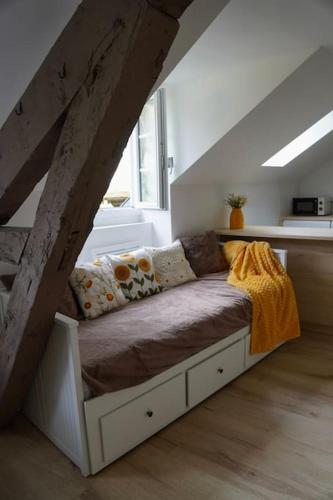 a room with a bed in the attic with a stair at Studio rénové dans le centre in Cauterets