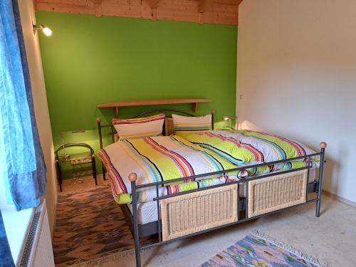 1 dormitorio con 1 cama con pared verde en Ferienwohnung Sonnenschein en Nagel