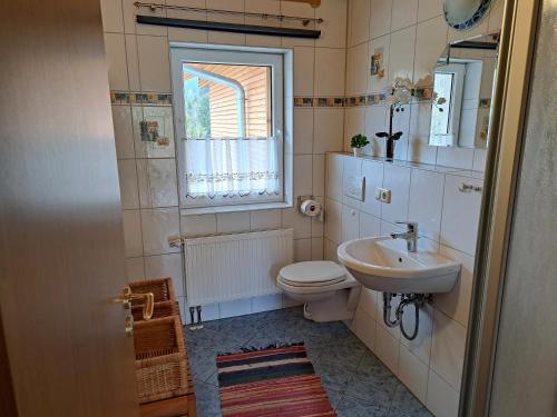 baño con lavabo y aseo y ventana en Ferienwohnung Sonnenschein en Nagel