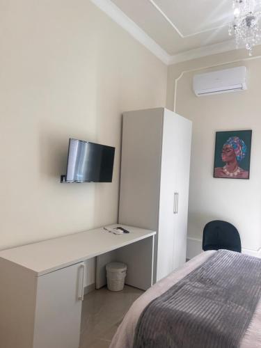 a white bedroom with a desk and a bed at Amaris in Palermo