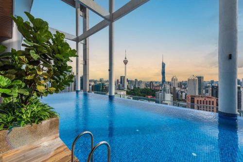 a swimming pool on top of a building with a city skyline at CL24A 5-6pax KLCC Sky Pool Condo in Kuala Lumpur