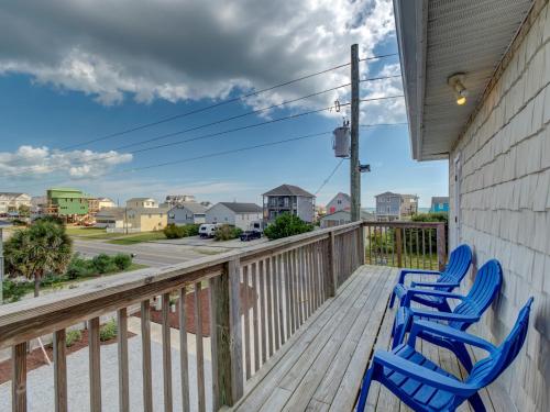two blue chairs on a deck with a view of the street at Unit 216S at Tiffany's in Surf City