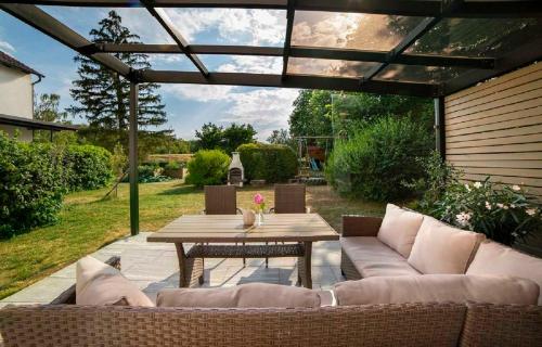 a patio with a table and couches and a table and chairs at Kur & Golf Ferienwohnungen Wattenbach in Bad Windsheim