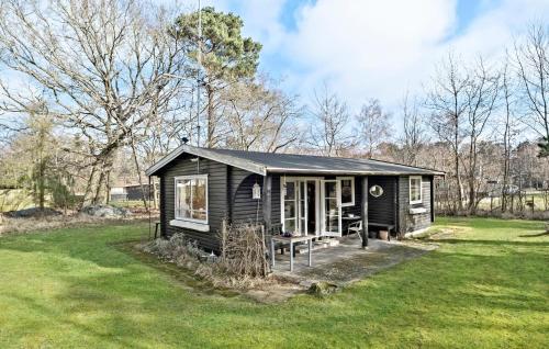 a small black cabin in a field of grass at Beautiful Home In Frederiksværk in Frederiksværk