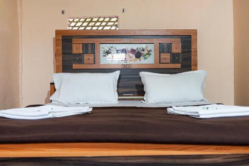 a bed with two white towels on top of it at Hippie Land Nature Stay in Hampi