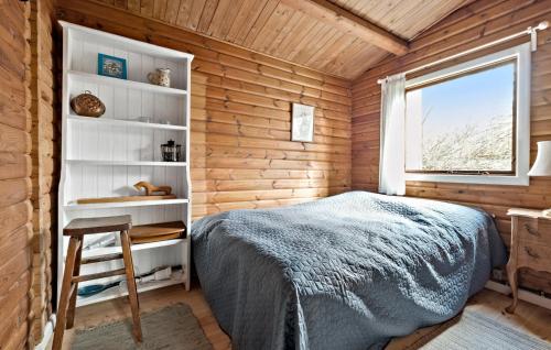 a bedroom with wooden walls and a bed and a window at Beautiful Home In Frederiksværk in Frederiksværk