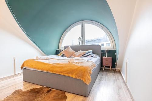 Bett in einem Zimmer mit einem großen Fenster in der Unterkunft Hauptbahnhof Boutique Rooms - Virtual Reception & Self-Checkin in Wien
