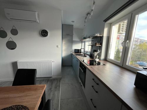 a kitchen with white walls and a wooden counter top at Apartament Hugo in Świnoujście